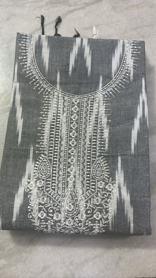 Black and white embroidered garment on a gray surface