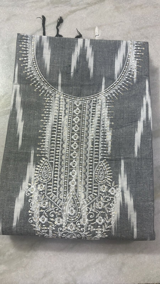 Black and white embroidered garment on a gray surface